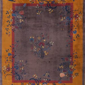 A plush purple rug features an intricate pattern of multi-colored flowers and vines inside a wide gold border.