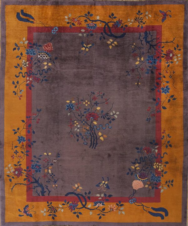 A plush purple rug features an intricate pattern of multi-colored flowers and vines inside a wide gold border.