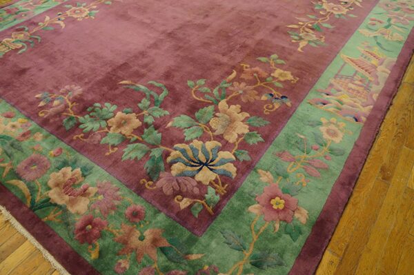 High-pile magenta rug with jade border features detailed botanical and scenic patterns on wood planks.