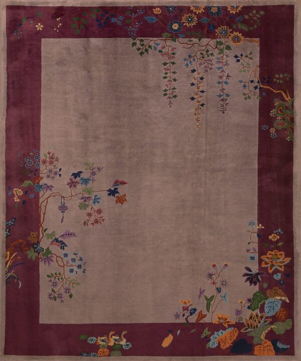 Taupe rug with a deep burgundy border and an elaborate design of colorful flowering branches and plants.