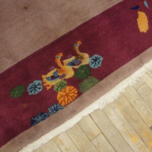 High-pile rug in burgundy and tan featuring sculpted ducks and foliage on worn wood floor.