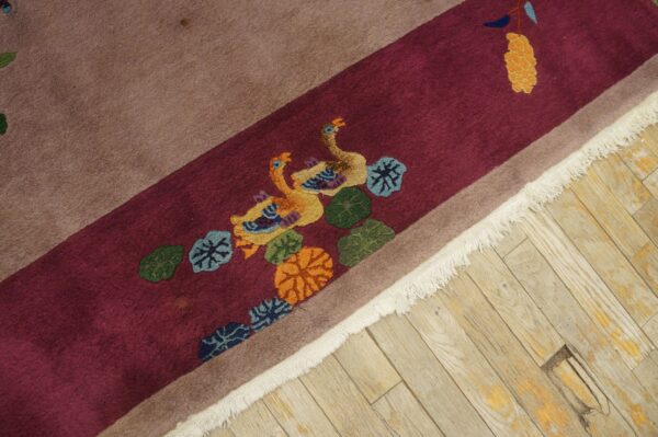 High-pile rug in burgundy and tan featuring sculpted ducks and foliage on worn wood floor.