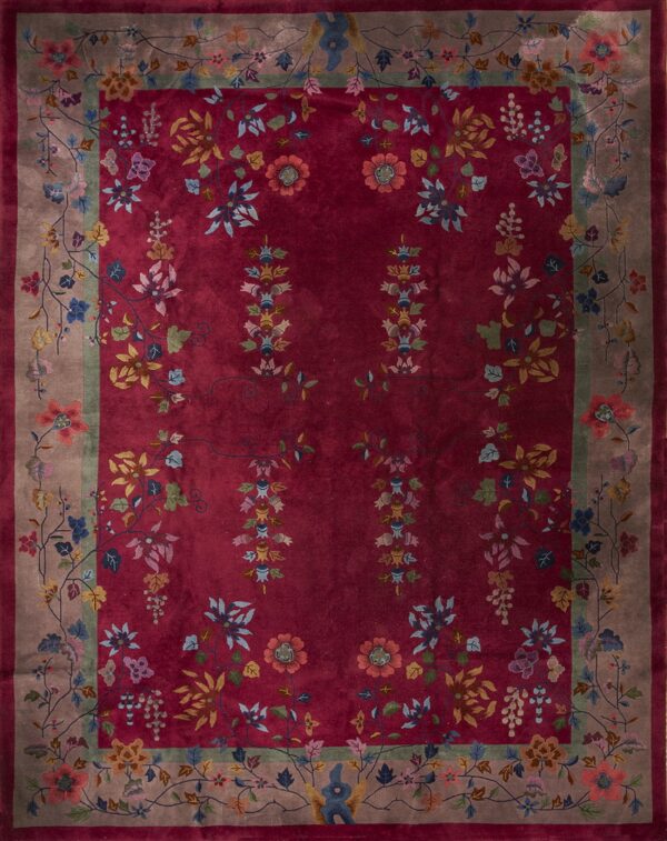 A deep red floral rug featuring multicolored blossoms and a wide taupe border with connecting vines.