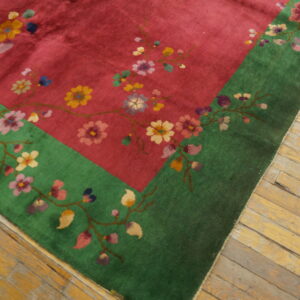 Magenta rug with colorful flowering branches and a bright green border sits on yellow wood floorboards.