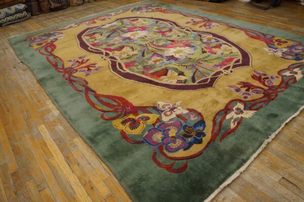 Plush golden art nouveau rug with vibrant floral designs and a sage border on worn wood floors.