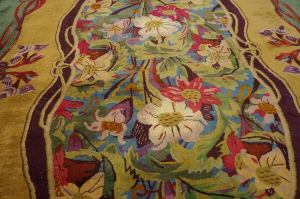 Sculpted pile rug displaying stylized flowers and foliage in gold, teal, pink, and purple colors.