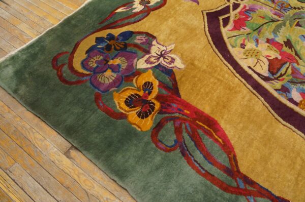 Close-up showing a high-pile floral rug with gold and green fields resting on worn hardwood.