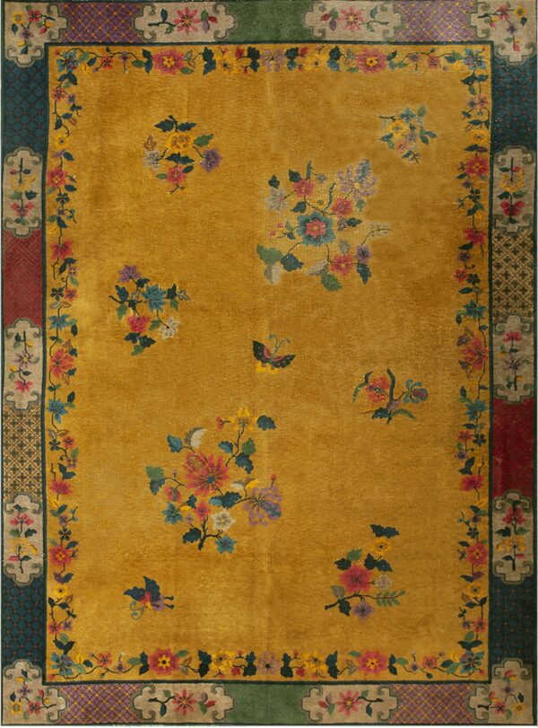 Gold field rug with multicolored florals and butterflies, surrounded by a complex border in teal, red, and purple.
