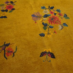 Mustard yellow rug featuring scattered floral and butterfly motifs in bright red, blue, and purple.