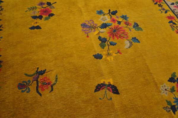 Mustard yellow rug featuring scattered floral and butterfly motifs in bright red, blue, and purple.