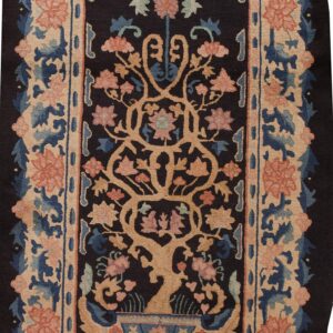Dark oval rug with a central tree motif and wide floral borders in tan, blue, and salmon.