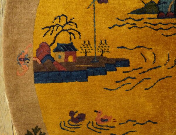 Mustard yellow rug with a scenic landscape design, detailed with blue waves, houses, and a tan border.