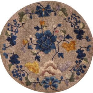 Round textured brown rug with large blue, yellow, and green stylized floral and vine designs.