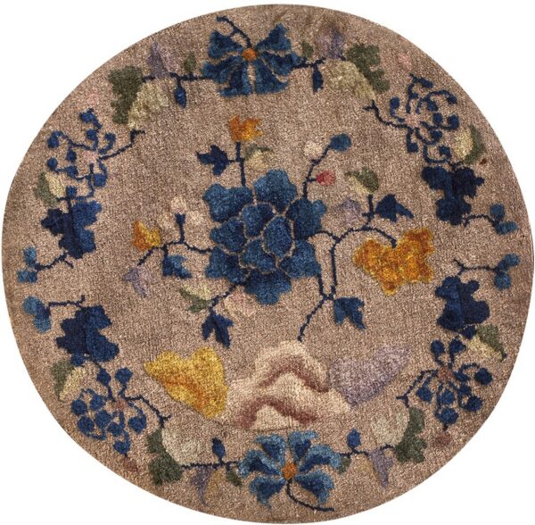 Round textured brown rug with large blue, yellow, and green stylized floral and vine designs.