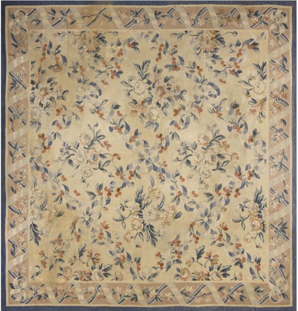 Beige floral rug with blue and pink flowers, featuring a ribbon motif border on a taupe background.