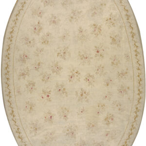 Oval cream rug with a scattered pattern of pale pink and tan roses and a light floral border.