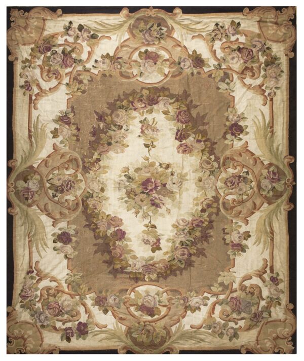 Low-pile rug with elaborate scrolling floral design in muted pink, green, cream, and brown tones.