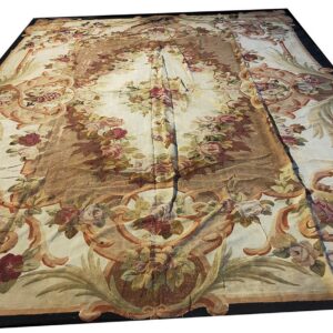 Cream low-pile rug with large floral motifs and scrolling vine patterns in rose, tan, and green.