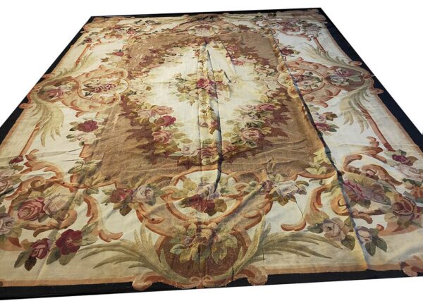 Cream low-pile rug with large floral motifs and scrolling vine patterns in rose, tan, and green.