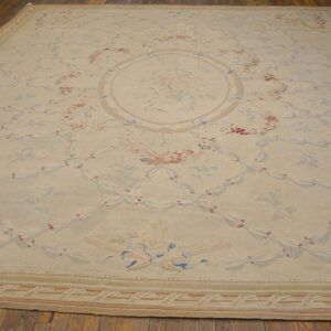 Cream area rug featuring a delicate pink and blue floral trellis pattern surrounding a central bouquet.