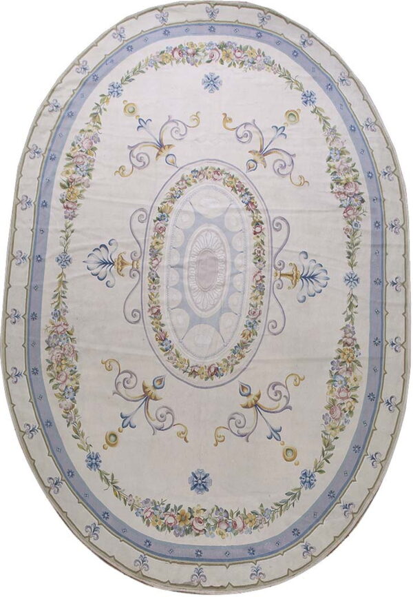 Oval cream rug with pale blue borders and intricate garlands of pink, yellow, and lavender flowers.