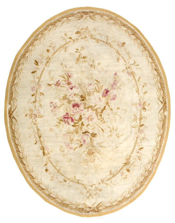 Round cream rug featuring a pink and tan floral bouquet medallion surrounded by a tan leaf garland border.