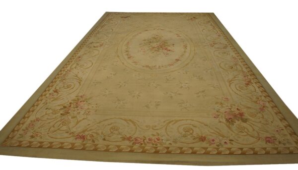 Long, low-pile rug with a beige ground, pink floral clusters, and intricate golden scrolling borders.
