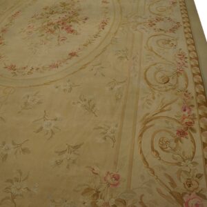 Detail of a pale gold rug showing pink roses, white floral sprigs, and tan neoclassical scrollwork.