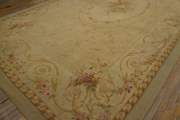 Cream and pale sage floral rug featuring pink roses and gold scrollwork on wood plank flooring.