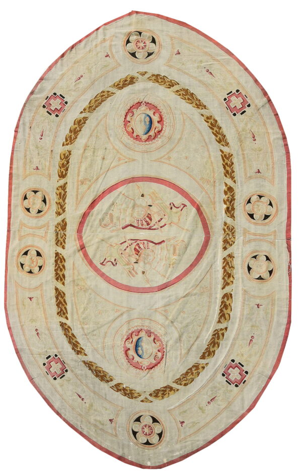 Oval rug featuring a cream field with neoclassical pink and golden-brown wreath and medallion patterns.