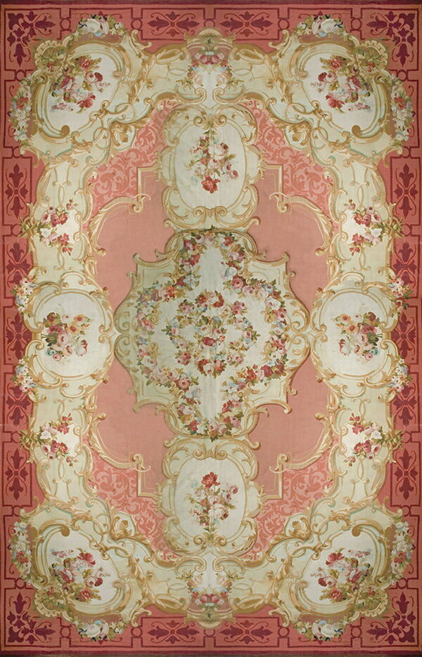 Ornate pink and cream traditional rug patterned with symmetrical medallions and multicolored floral clusters.
