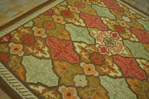 Rust, olive, orange, and sage geometric tile pattern rug displayed on light distressed wooden floor.