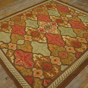 Multicolored rug featuring orange, red, and sage green tile-like floral patterns on distressed hardwood planks.