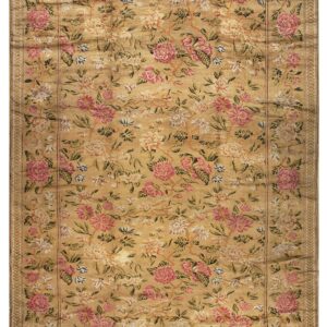Golden yellow rug with a dense, all-over floral pattern featuring large pink, cream, and blue blossoms.