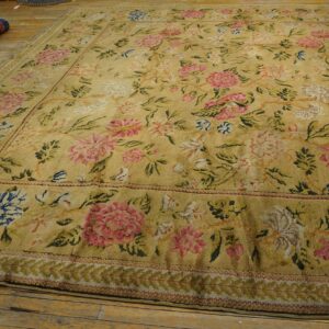 Distressed golden rug featuring a dense pink and blue floral pattern and multiple decorative borders.