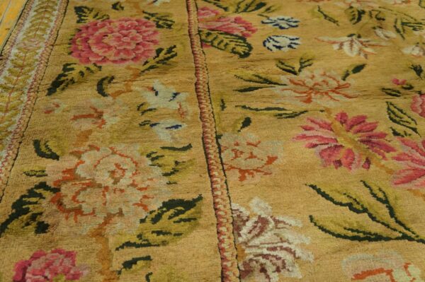 Textured yellow rug with large pink, olive green, and orange floral patterns.