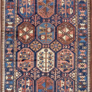 Geometric runner rug with alternating blue and rust medallions surrounded by intricate patterns.