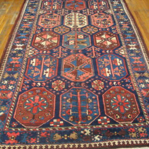 Navy blue and brick red geometric runner rug with a repeating medallion pattern on wood floors.