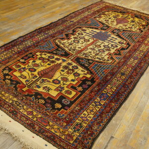 Geometric yellow, red, and blue runner rug with fringed ends placed diagonally on plank wood flooring.