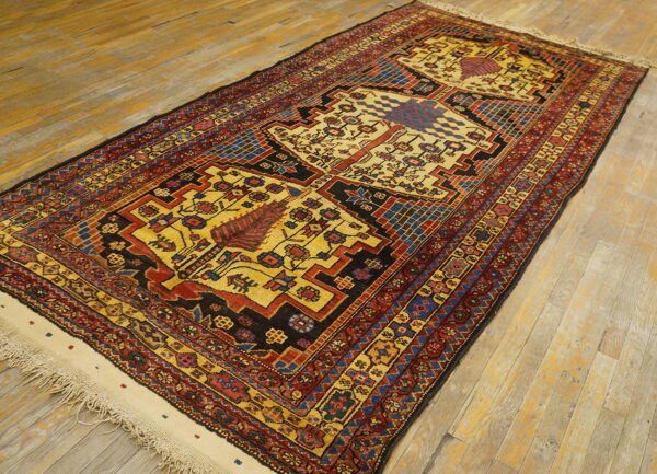 Geometric yellow, red, and blue runner rug with fringed ends placed diagonally on plank wood flooring.