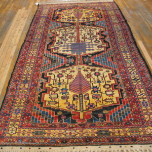 Low-pile, tribal rug featuring red, yellow, blue, and black geometric patterns on a wood floor.