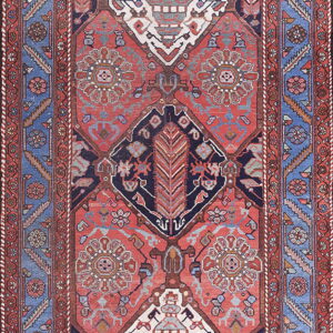 Red and navy tribal rug with a central row of three large diamond medallions and blue borders.