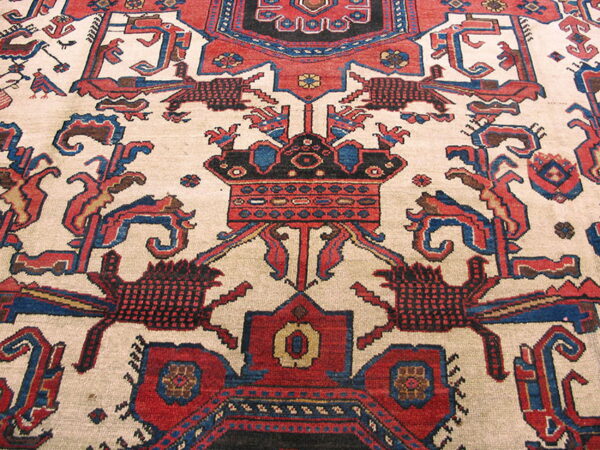Low-pile rug detail showing a highly stylized geometric pattern with red, blue, black, and cream colors.