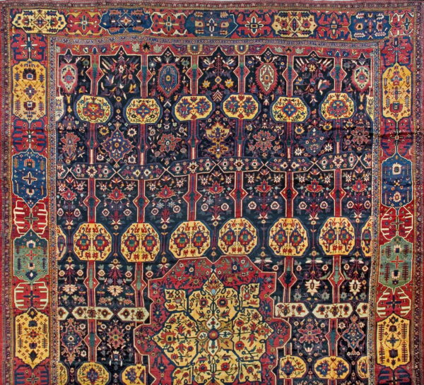 Intricate traditional rug pattern with a navy field, detailed red borders, and bright yellow medallions.