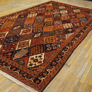 Red and navy geometric rug with a detailed medallion grid pattern on light golden wood floors.