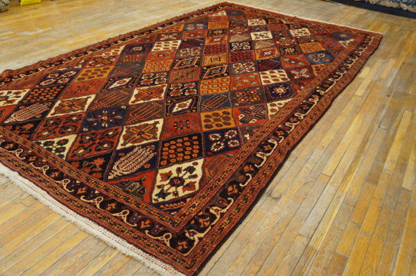 Red and navy geometric rug with a detailed medallion grid pattern on light golden wood floors.