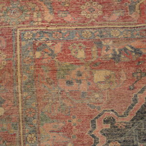 Flatweave rug with a ribbed texture featuring red, blue, and tan geometric and floral motifs near the border.