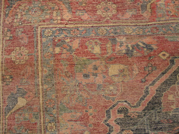 Flatweave rug with a ribbed texture featuring red, blue, and tan geometric and floral motifs near the border.