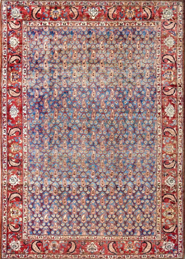 A low-pile rug featuring a faded blue field with an all-over paisley pattern and a wide red floral border.