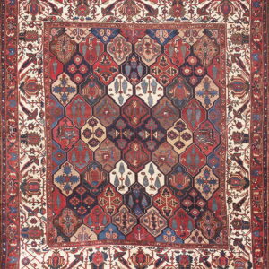 Rich red and blue rug featuring a field of complex interlocking geometric medallions and wide patterned borders.